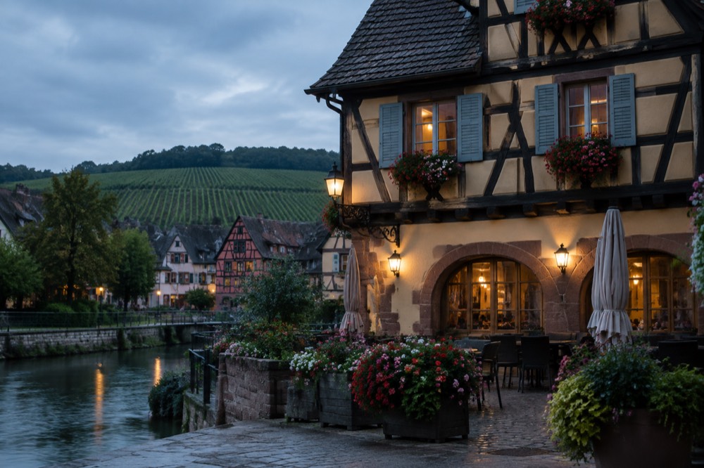 Half-timbered hotel facade with flower boxes in a village square at dusk