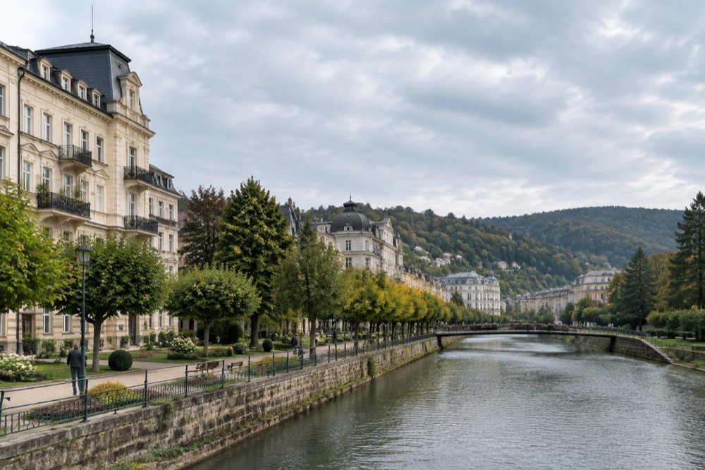 Tree-lined avenue and grand facades of a German spa town beneath wooded hills