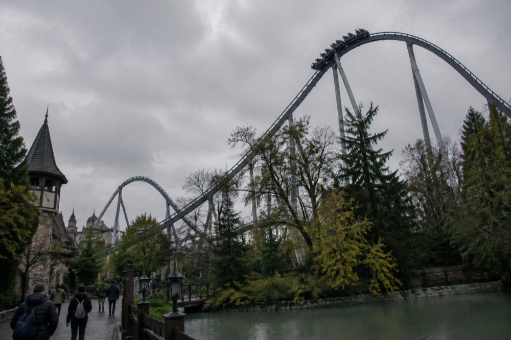 Roller coaster track rising above the treeline of a large theme park