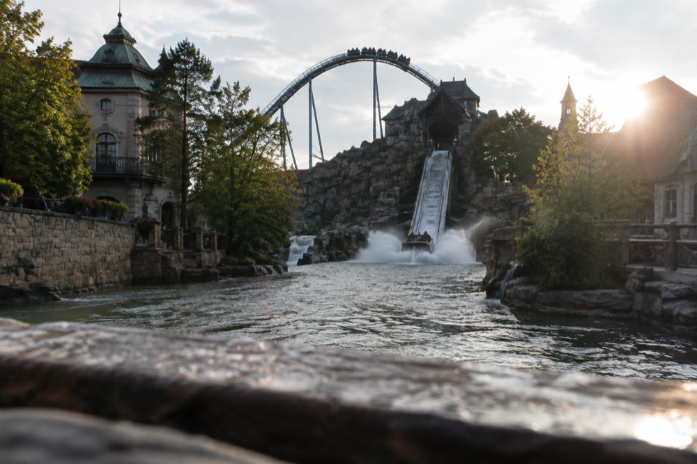Water ride splashing down a chute between themed rockwork