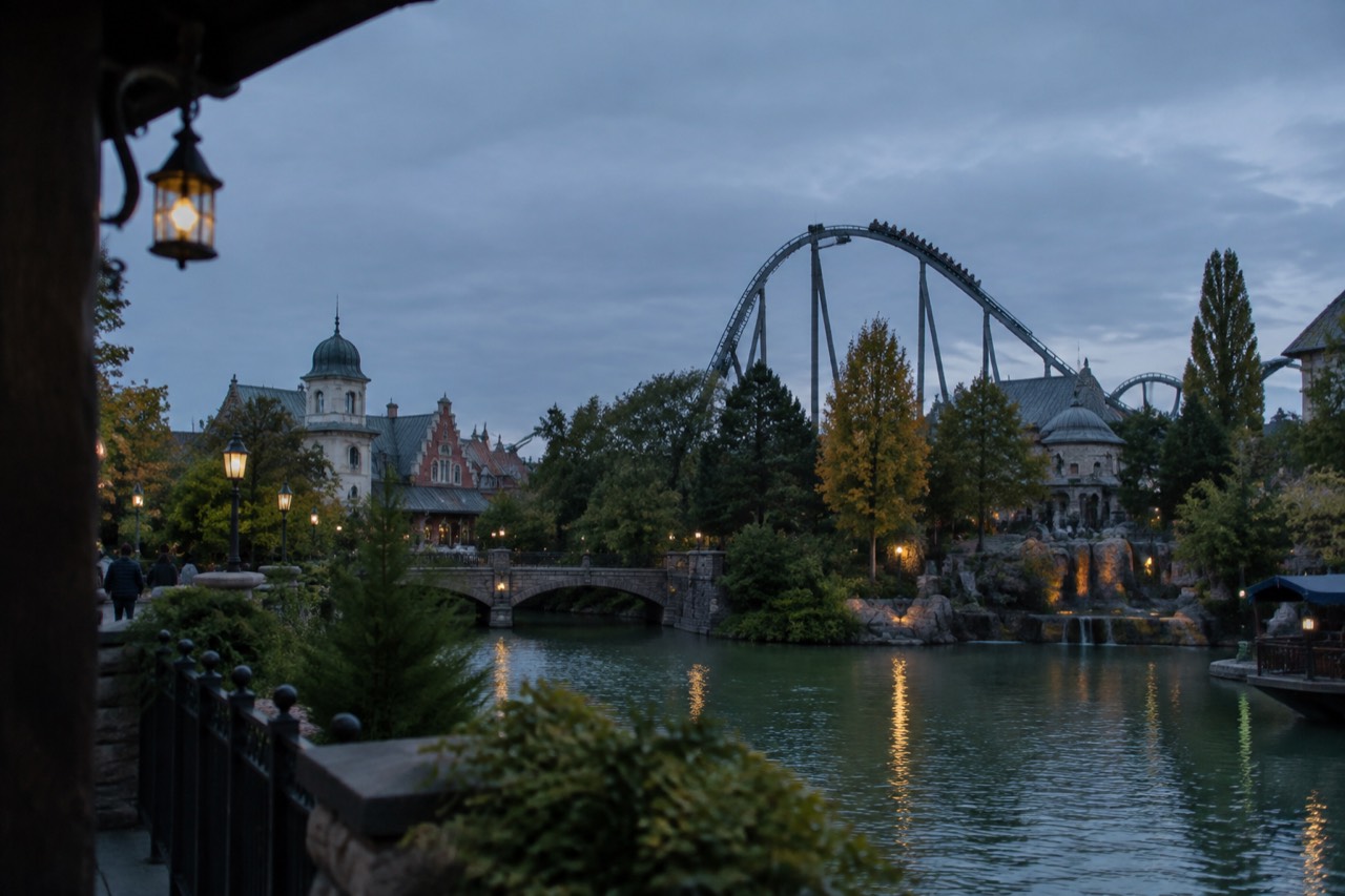 Roller coaster track rising above the treeline of a large theme park
