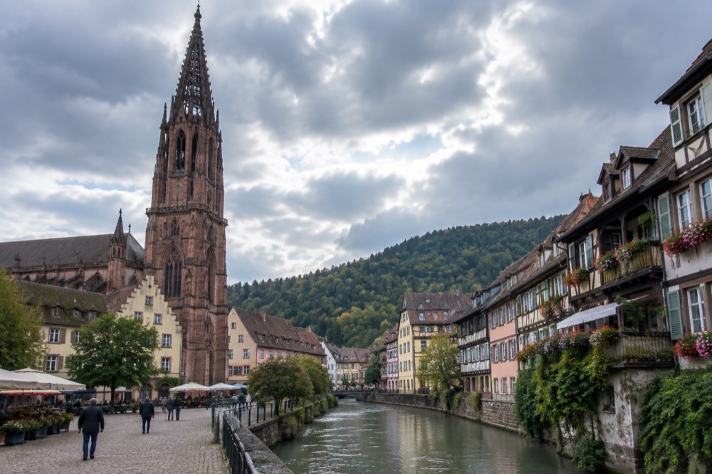 Half-timbered houses along a canal in a small Alsatian town with flower-decked balconies