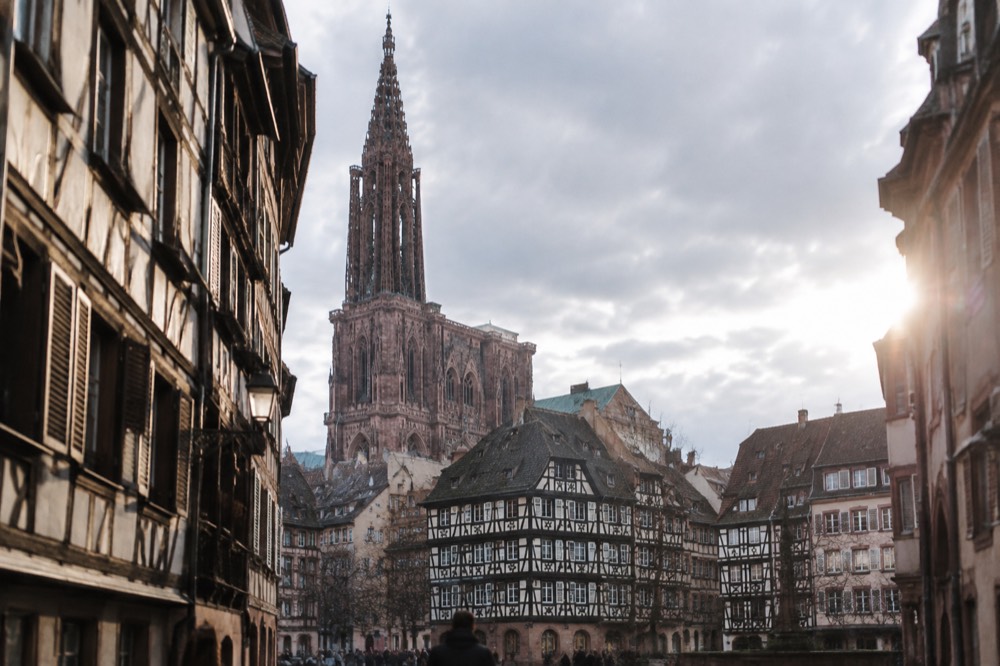 Strasbourg cathedral spire rising above old rooftops seen from a distance