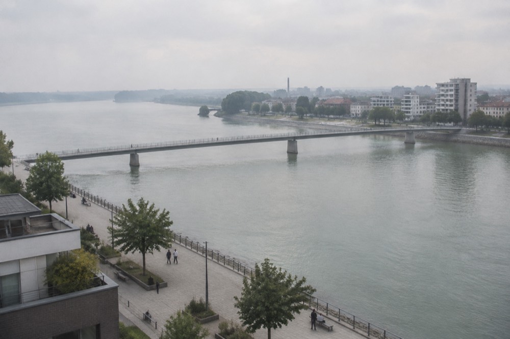 Two riverbanks facing each other across wide water under an open sky