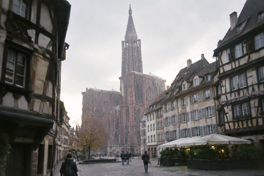 The single spire of Strasbourg Cathedral rising above the rooftops at dusk