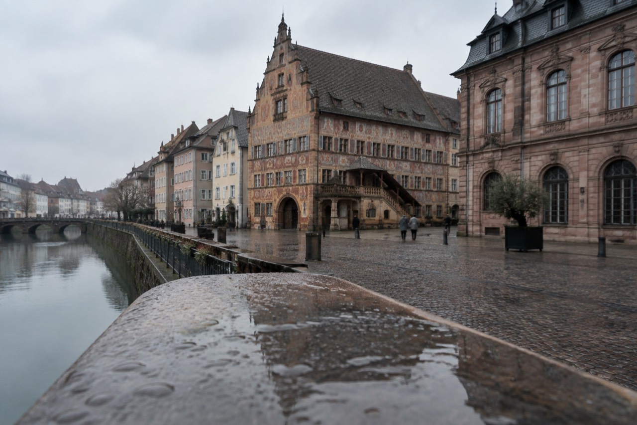 Historic stone buildings and a museum facade beside a quiet square in central Mulhouse