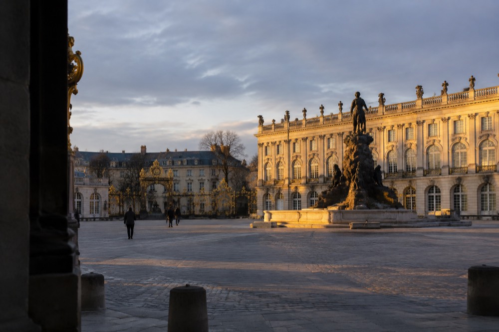 Evening light on a gilded fountain and classical building facade