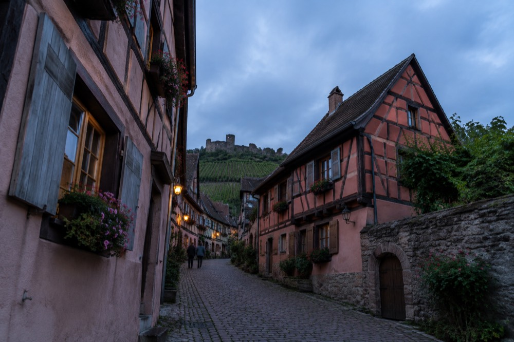 A cobbled street of colourful half-timbered houses in an Alsatian wine village