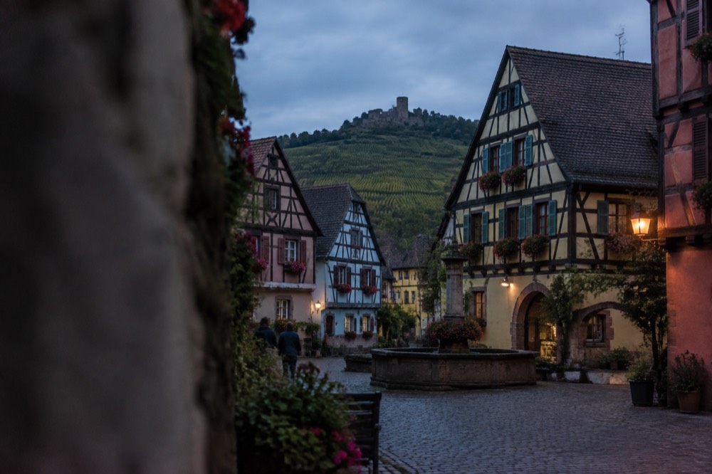 Half-timbered houses with steep roofs seen from a quiet village square