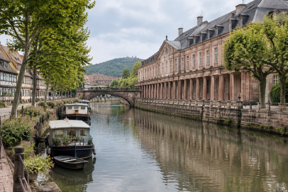 Half-timbered houses along a quiet canal in a small Alsatian town