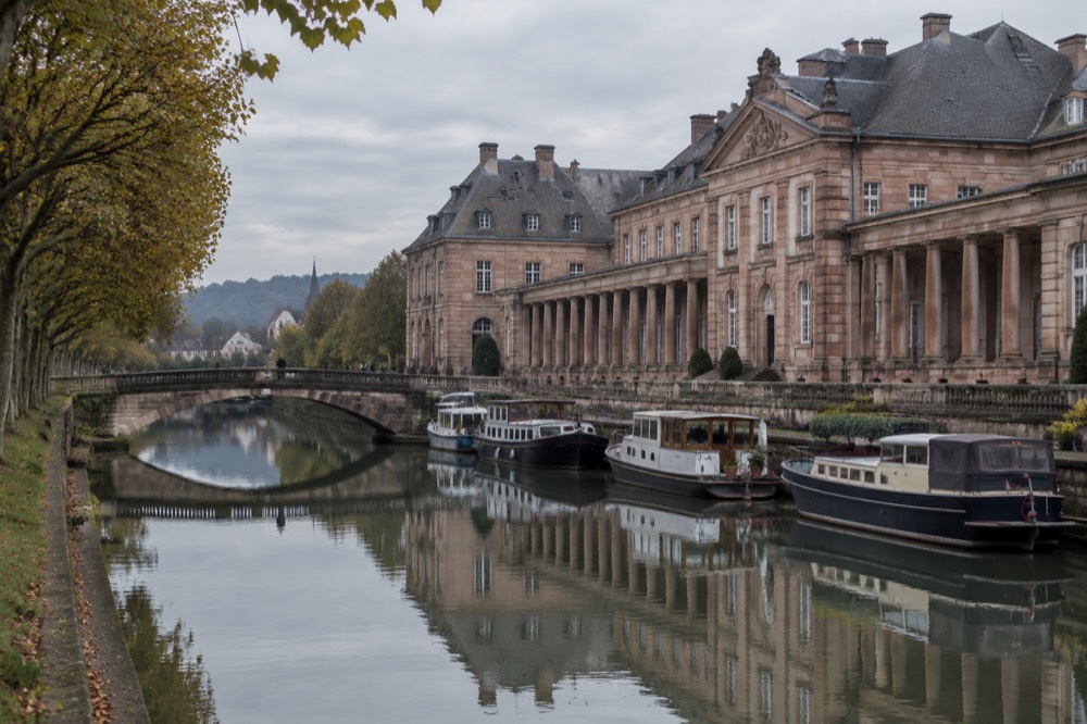 A classical château facade reflected in a still canal