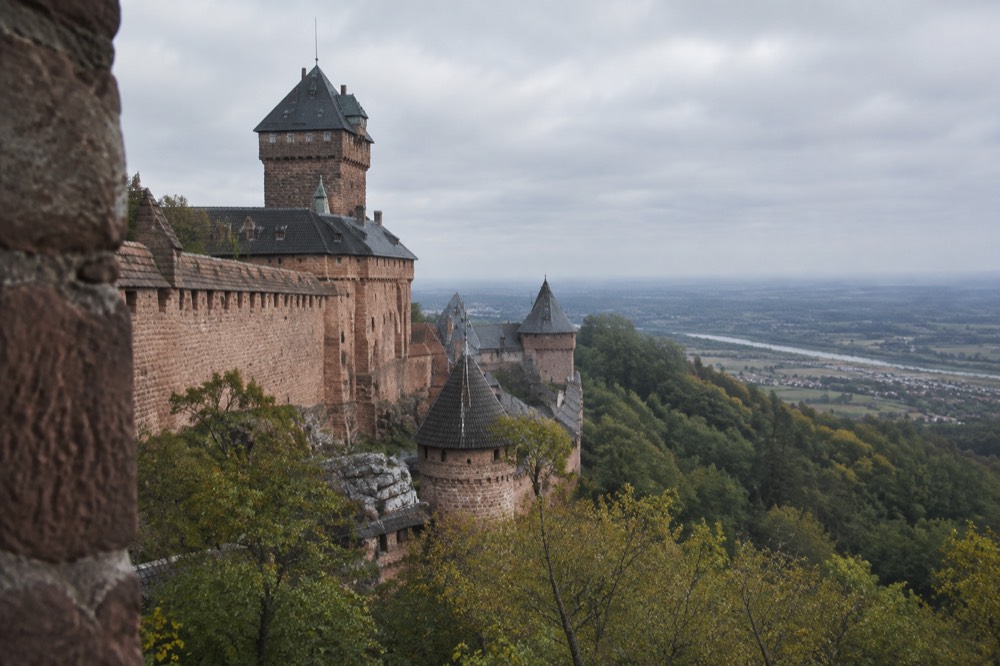 A stone watchtower on a wooded hill above the Alsatian plain