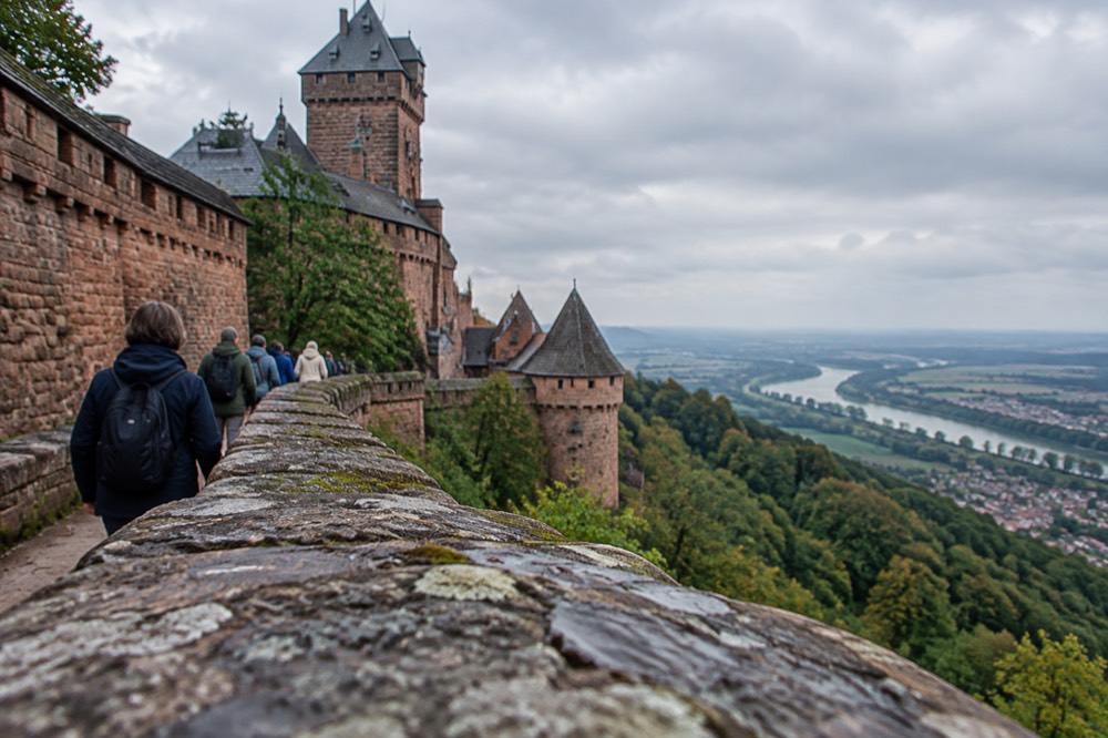 A guided group walking along a rampart path above the Alsace plain