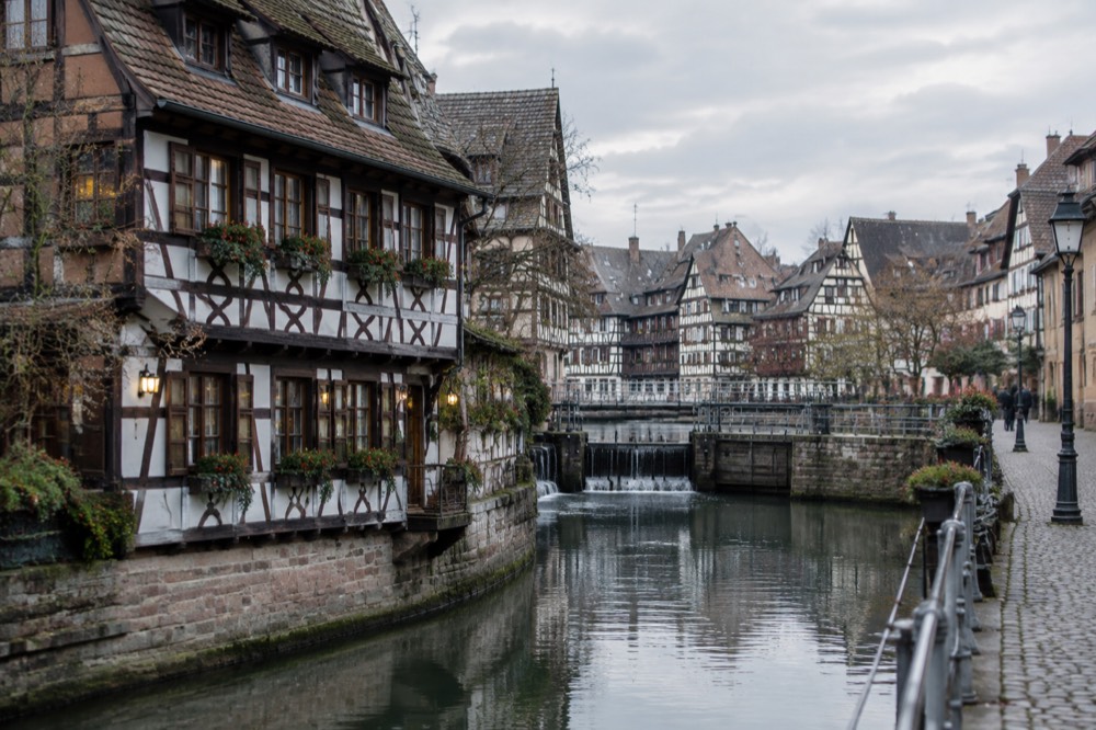 A half-timbered winstub facade with painted signs in the old streets of Strasbourg