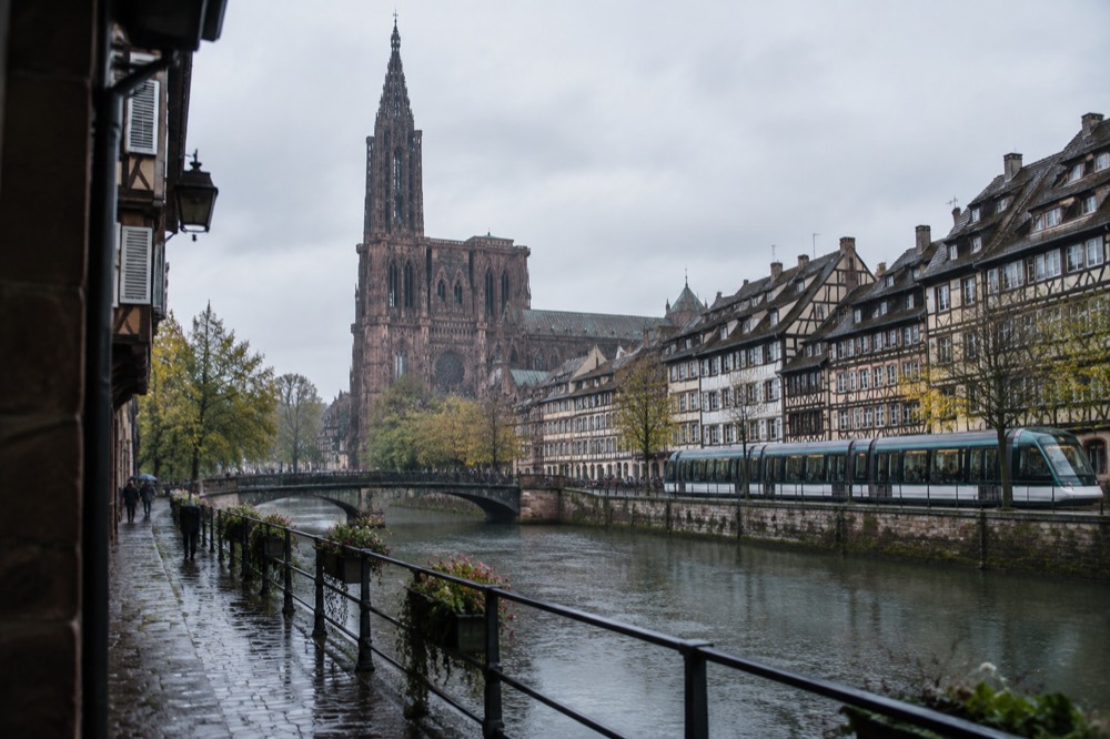 A tram passing half-timbered houses along the river Ill in central Strasbourg