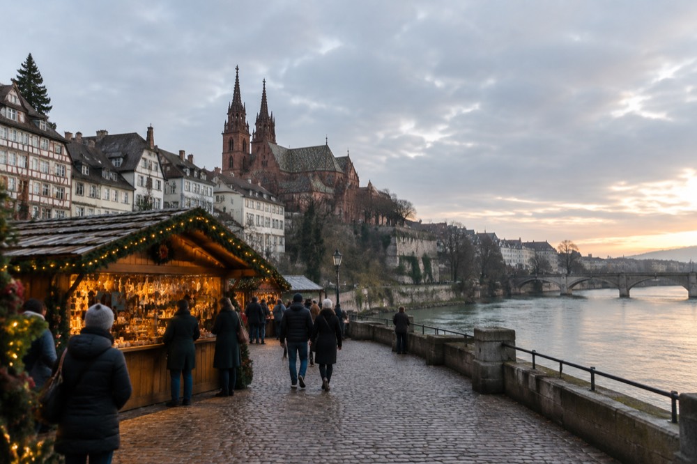A wooden market chalet with garlands and glowing lights on a cobbled square at dusk