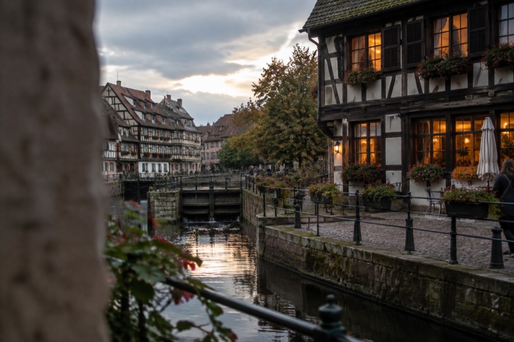 A half-timbered winstub facade in Strasbourg at dusk with warm light in the windows