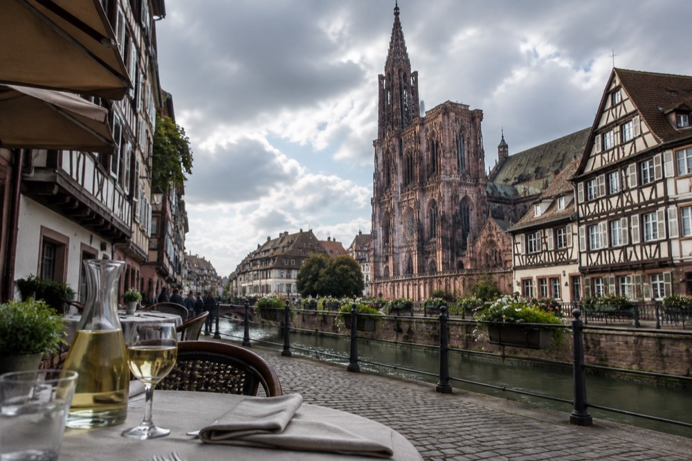 A set restaurant table with a carafe of white wine and folded napkins in Strasbourg