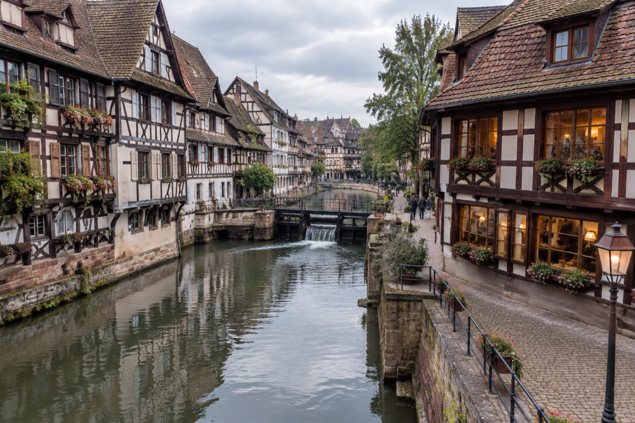 A half-timbered winstub facade in Strasbourg at dusk with warm light in the windows