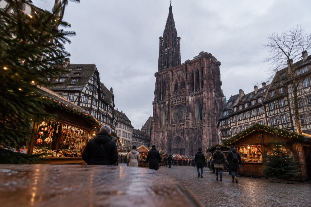 Christmas market chalets and decorated streets around Strasbourg Cathedral at dusk