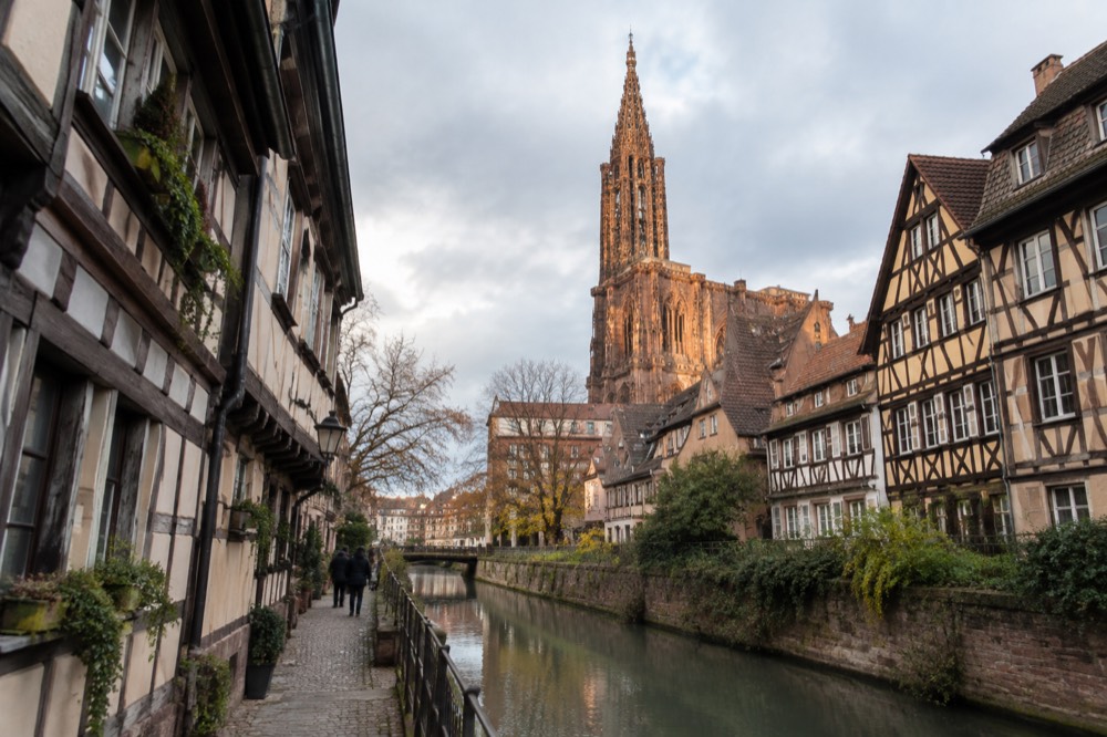 A narrow street of half-timbered houses beside a canal in the historic centre of Strasbourg