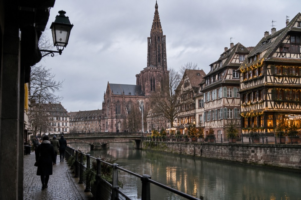 Festively lit timber-framed buildings beside a canal in Strasbourg, France