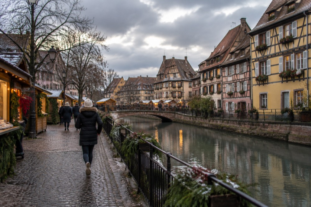 A small square in an Alsatian wine village with lights and market chalets