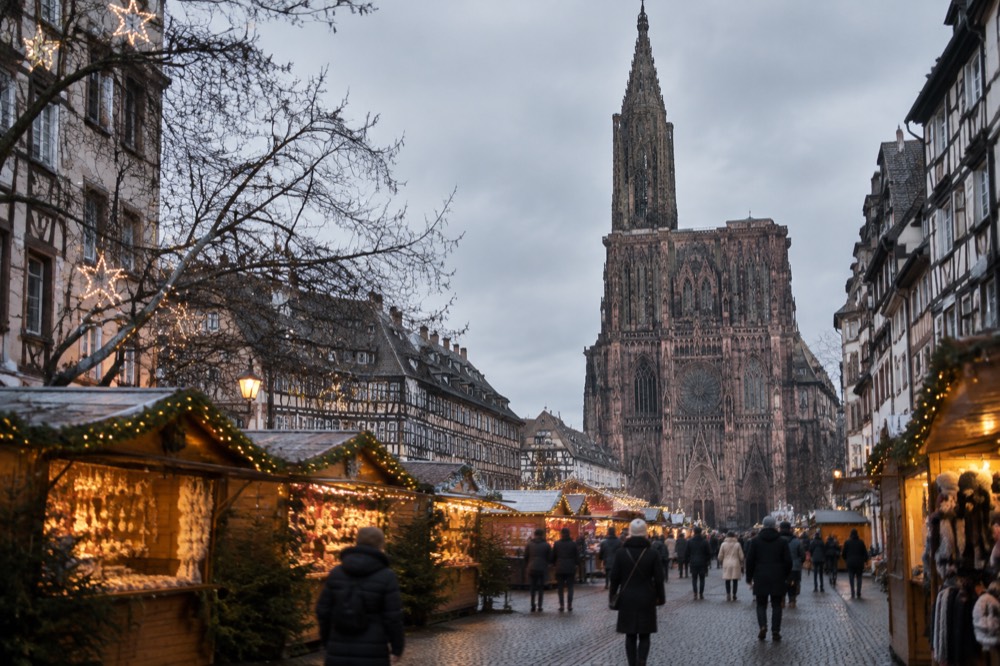 Illuminated market chalets and a decorated street in Strasbourg at night