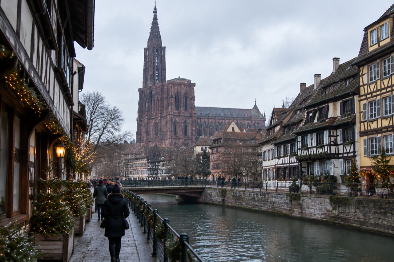 Festively lit timber-framed buildings beside a canal in Strasbourg, France