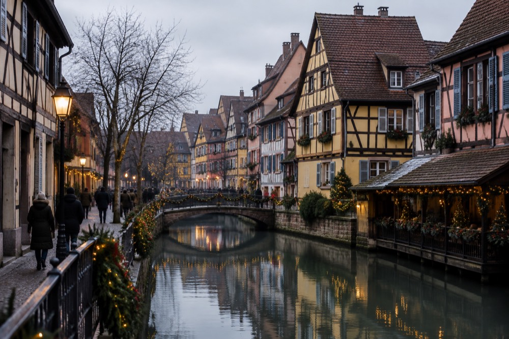 A half-timbered street in Colmar lit for Christmas at night