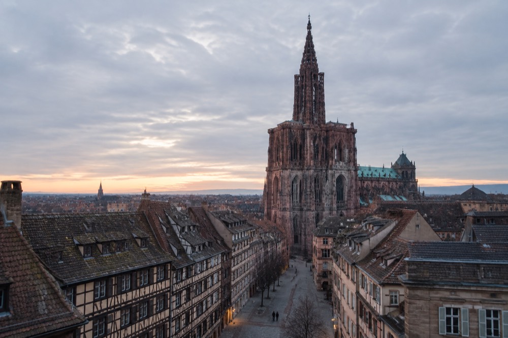 Strasbourg Cathedral and old rooftops seen across the city at dusk