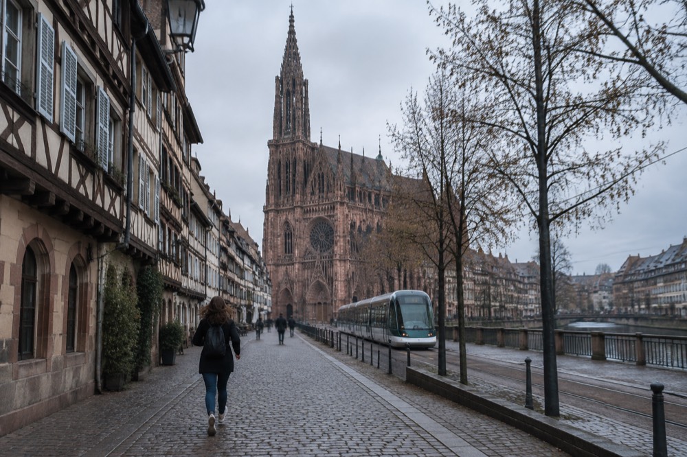 Modern tram gliding along a Strasbourg boulevard lined with trees