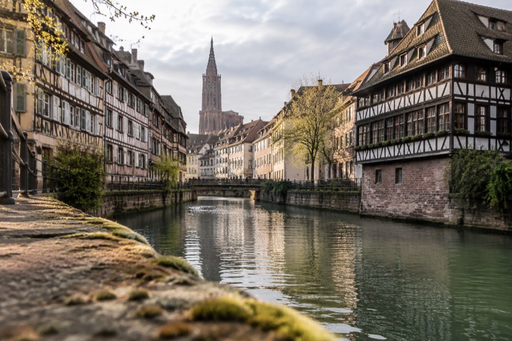 Half-timbered houses along a canal in Strasbourg's old quarter on a bright morning