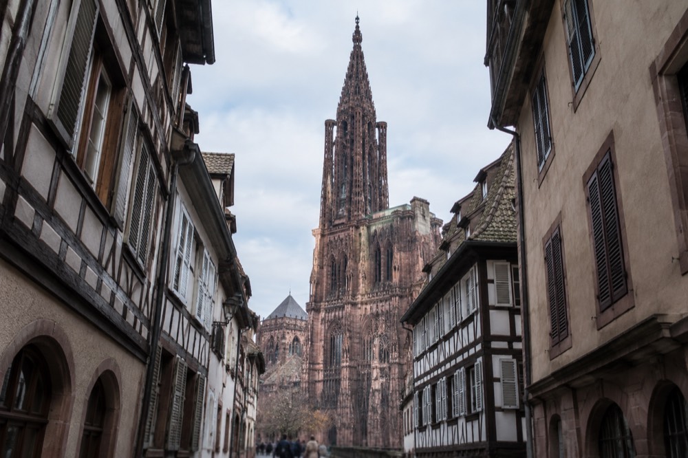 Cathedral spire seen from a narrow lane between old houses in Strasbourg