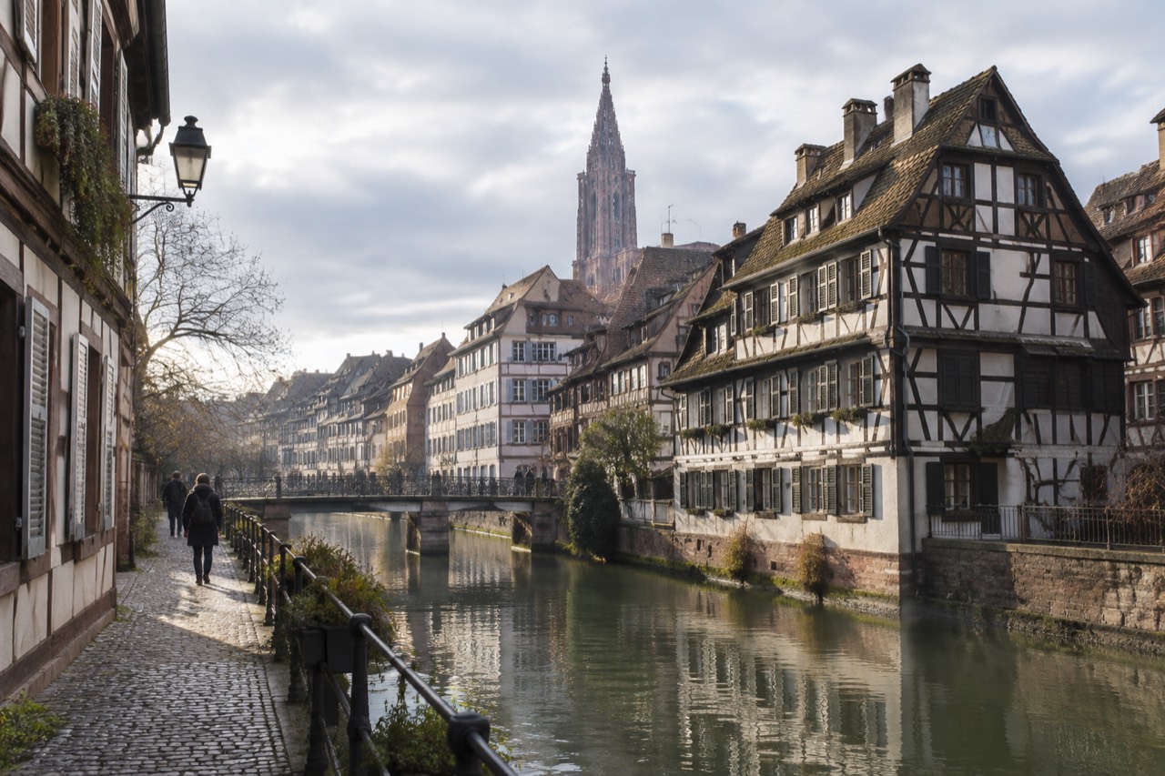 Half-timbered houses along a canal in Strasbourg's old quarter on a bright morning