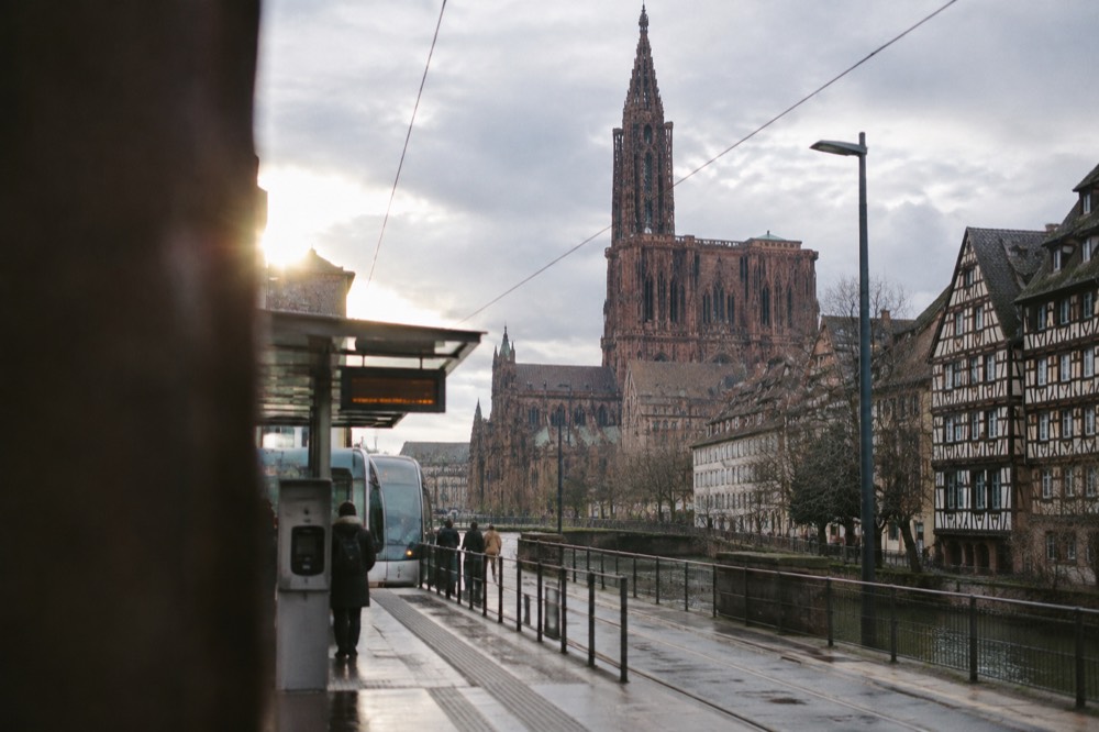 A tram stop with a ticket machine and route display on a Strasbourg boulevard