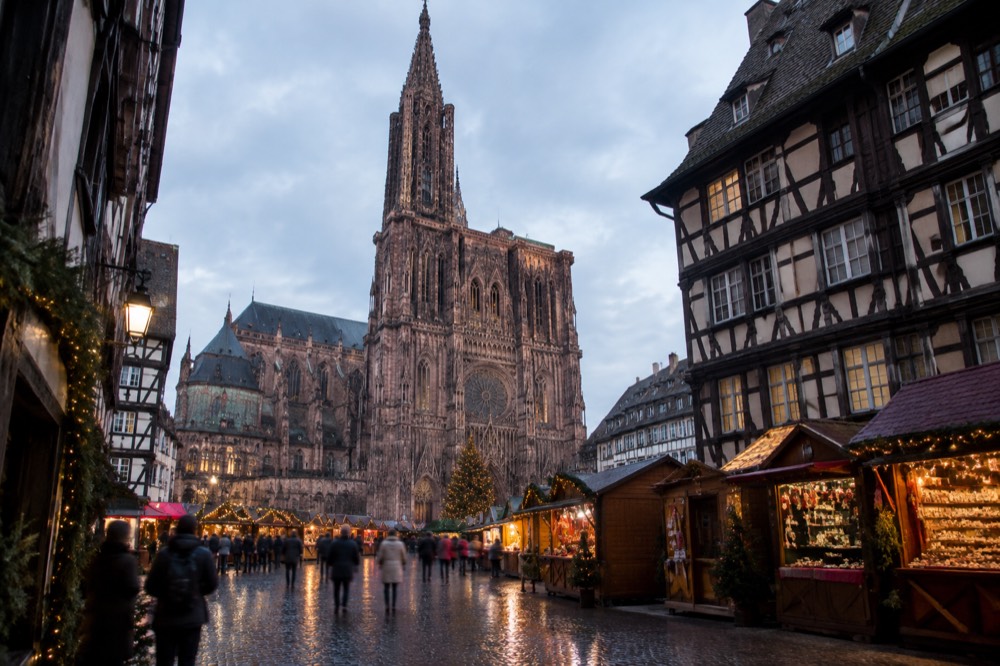 Festive market stalls and illuminated streets around the cathedral in Strasbourg at dusk