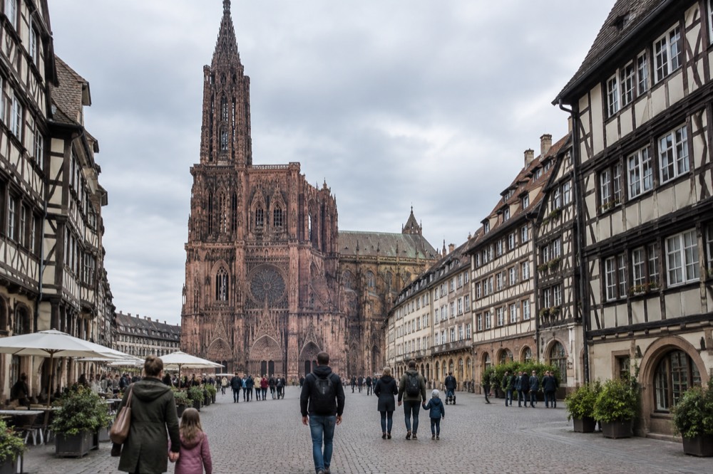 Families walking on a wide pedestrian square in Strasbourg