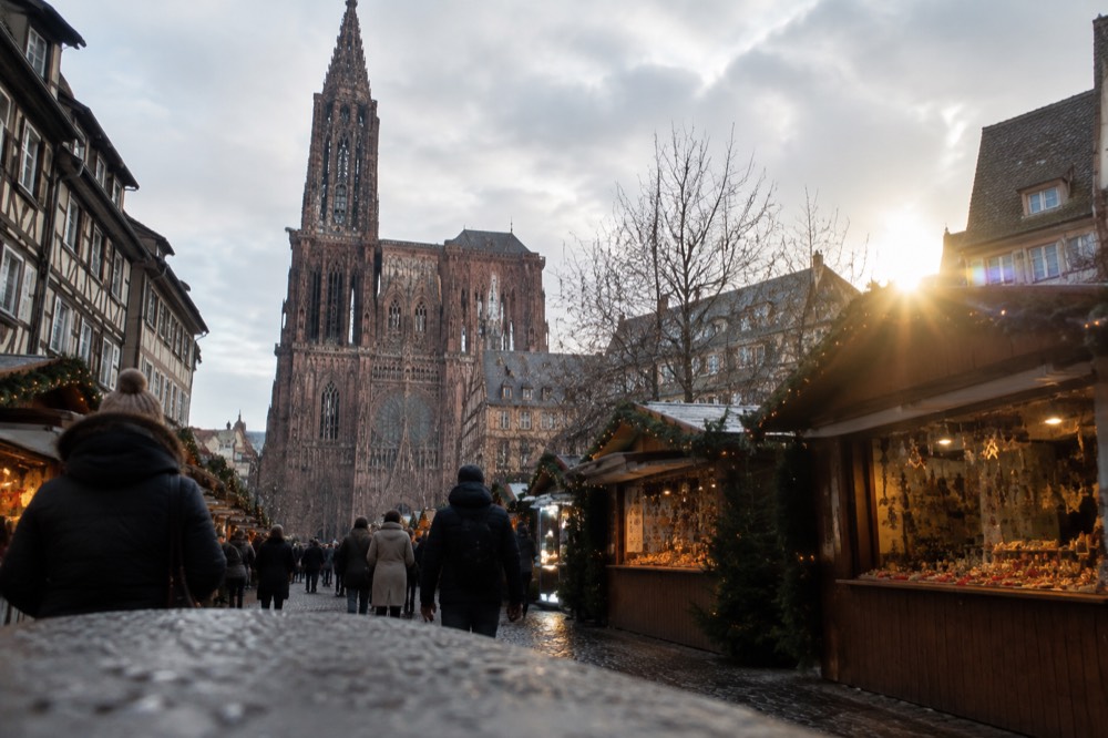 A street of wooden Christmas market chalets decorated with lights in Strasbourg