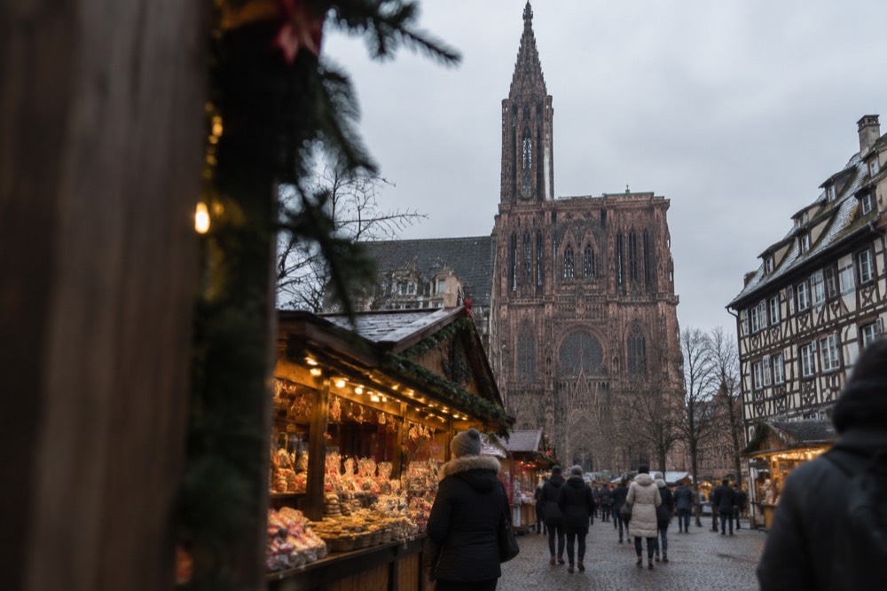 A Christmas market chalet in Strasbourg with cakes and biscuits displayed under warm lights