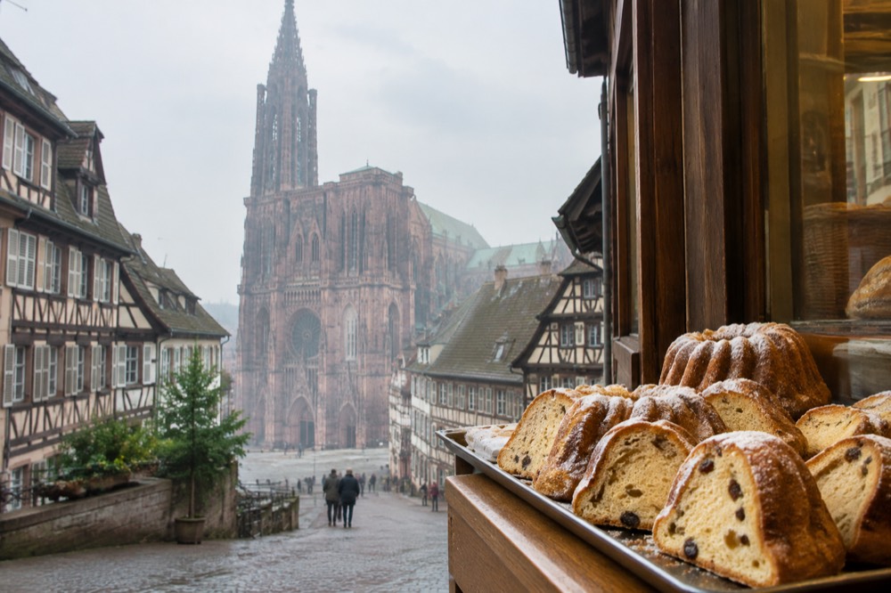 A tray of kougelhopf slices on a bakery counter in a Strasbourg side street