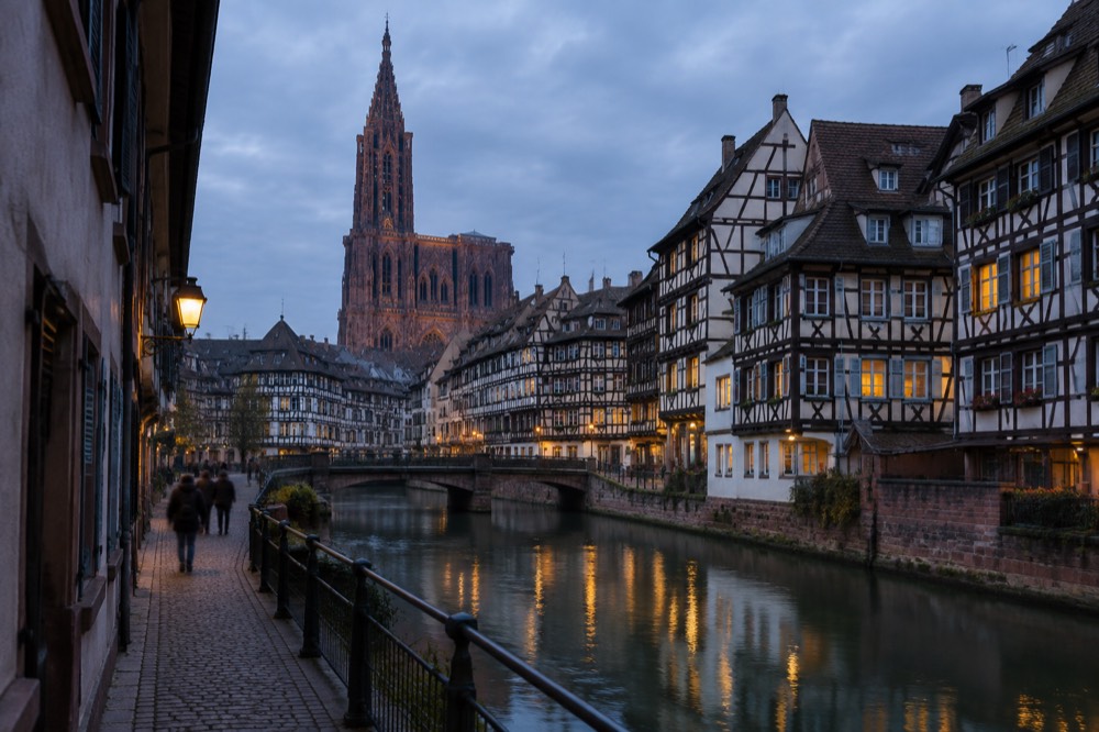Half-timbered houses along a canal in Strasbourg at dusk