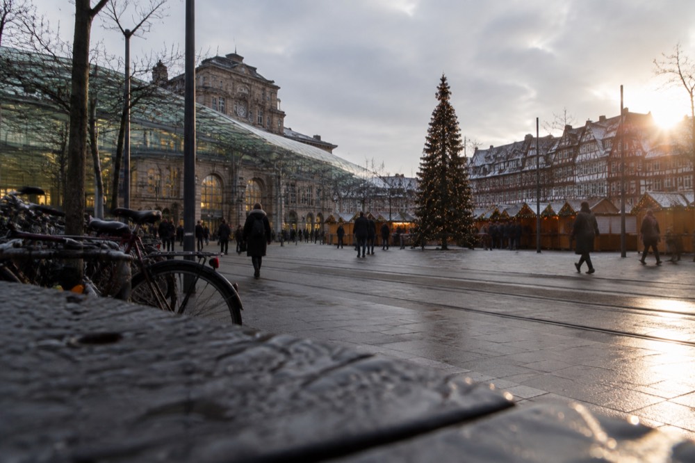 A Christmas market square with a decorated tree and timber-framed buildings