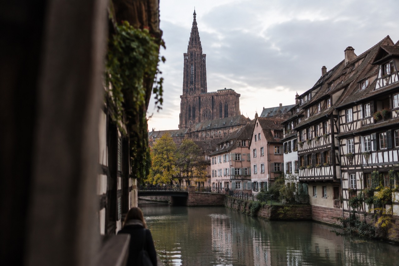 Half-timbered houses along a canal in Strasbourg at dusk