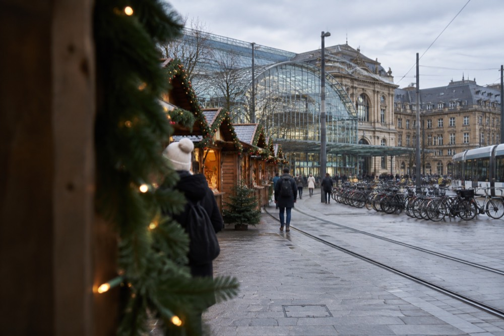 Festive wooden market chalets with garlands along a darkened old street