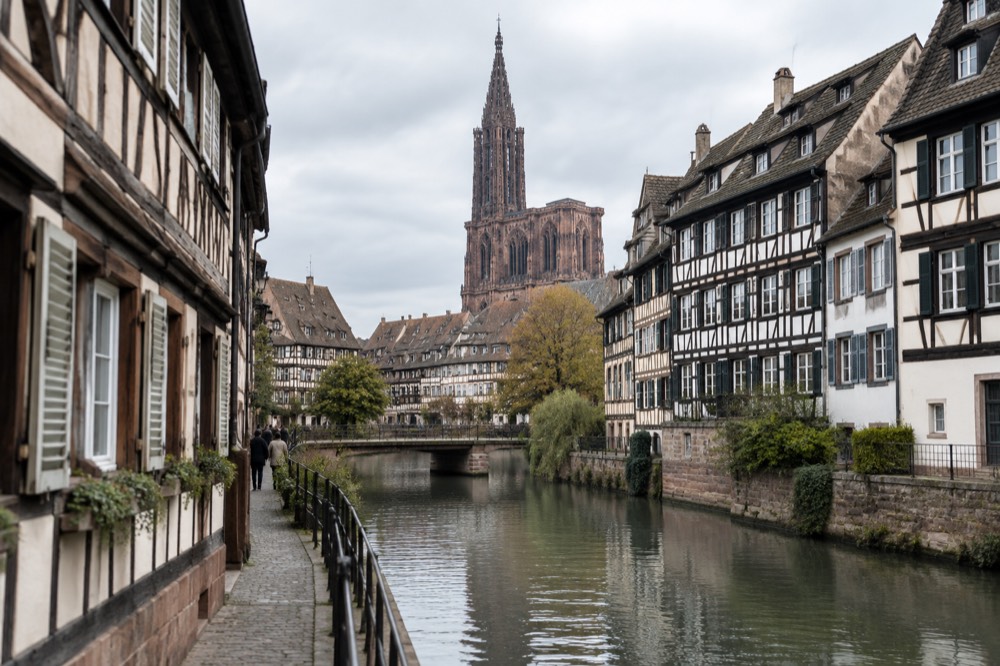 A narrow street of half-timbered houses along a canal in central Strasbourg