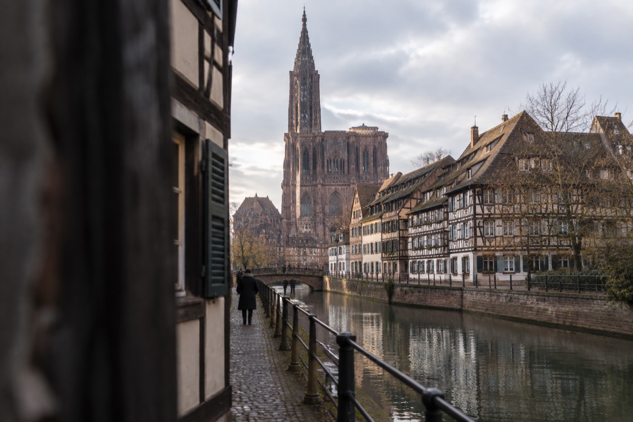 A quiet Alsatian street lined with half-timbered buildings beside a canal in central Strasbourg