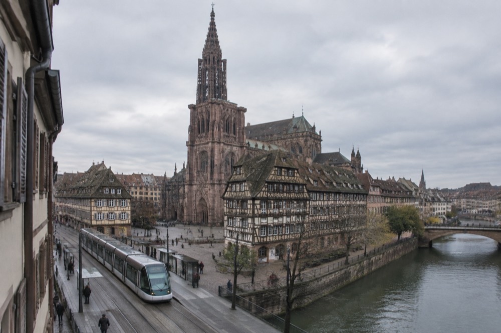 Modern low-floor tram standing at a stop on a wide Strasbourg boulevard