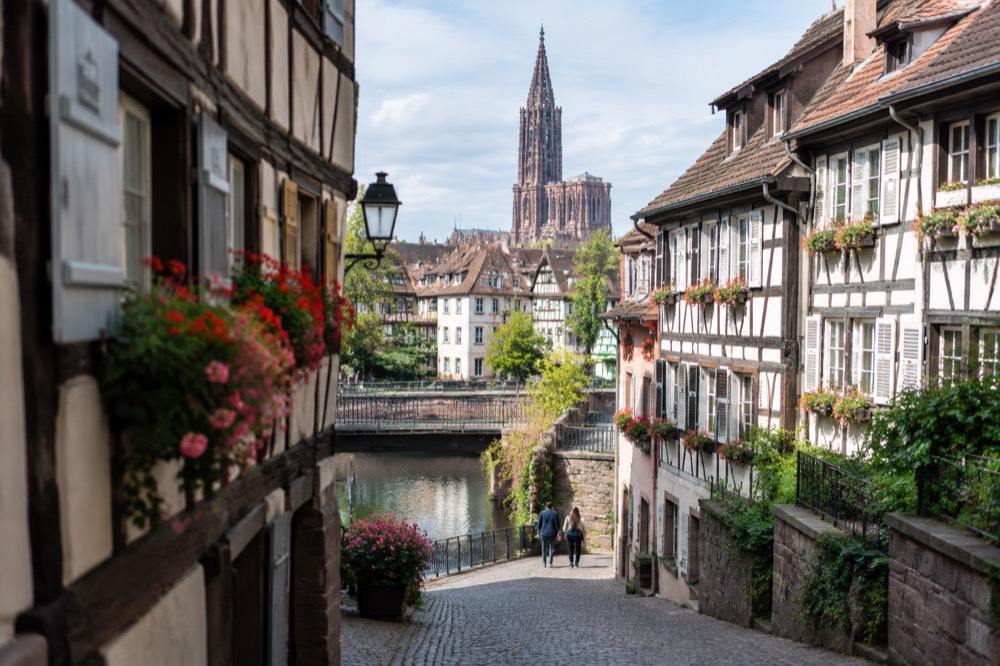 Cobbled lane of a hillside Alsace wine village lined with flowered half-timbered houses