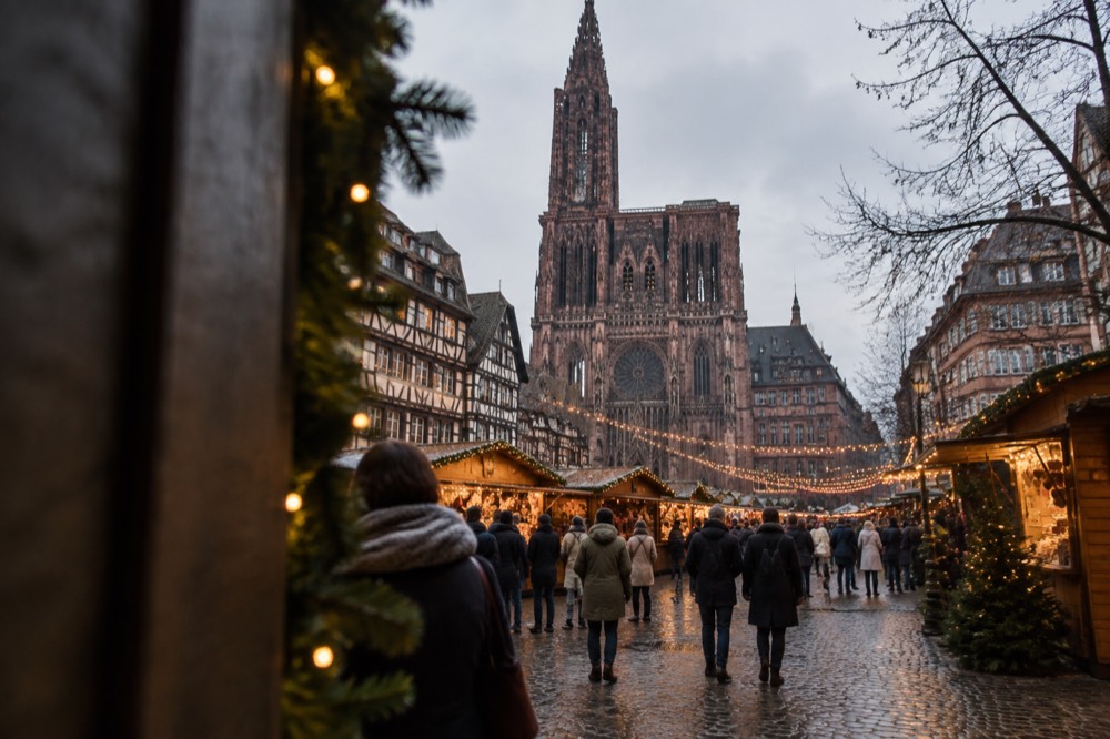 Christmas market chalets and strings of lights above a square in Strasbourg at night